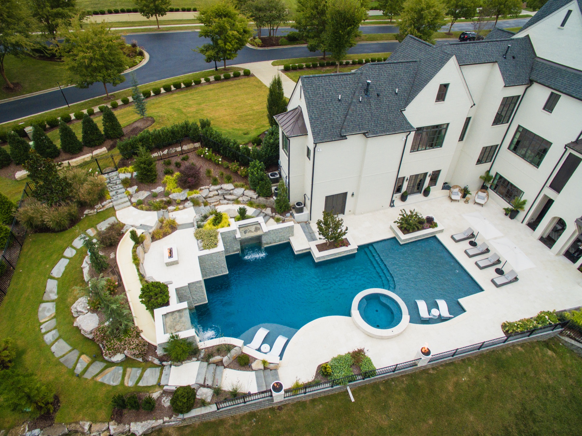 Aerial view of large freeform gunite pool with spa and extensive landscaping in Nashville