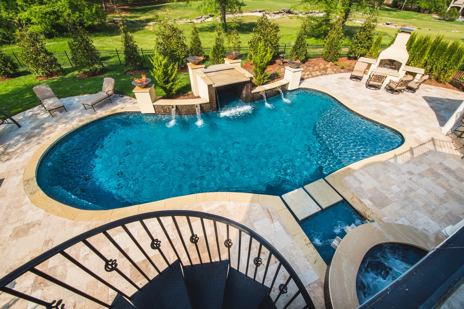 Custom pool with scupper waterfall features and stone fireplace in Nashville backyard